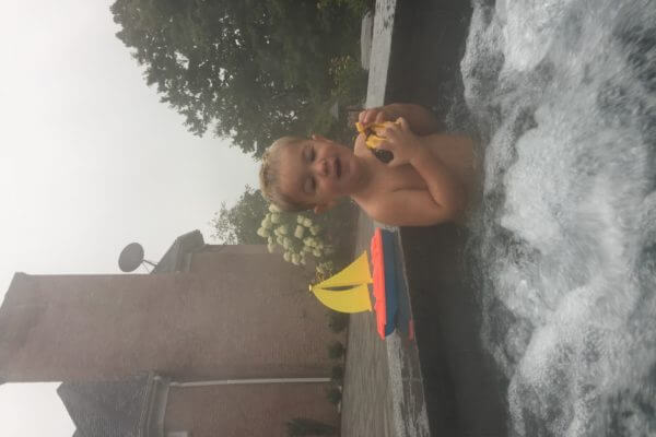 Child Playing in Hot Tub with Boat