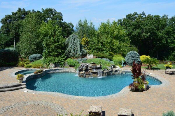 Aqua Pool & Patio gunite swimming pool construction in Connecticut showing swimming pool with attached spa and waterfall