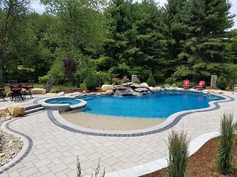 Aqua Pool & Patio gunite swimming pool construction in Connecticut showing pool with waterfall and spa