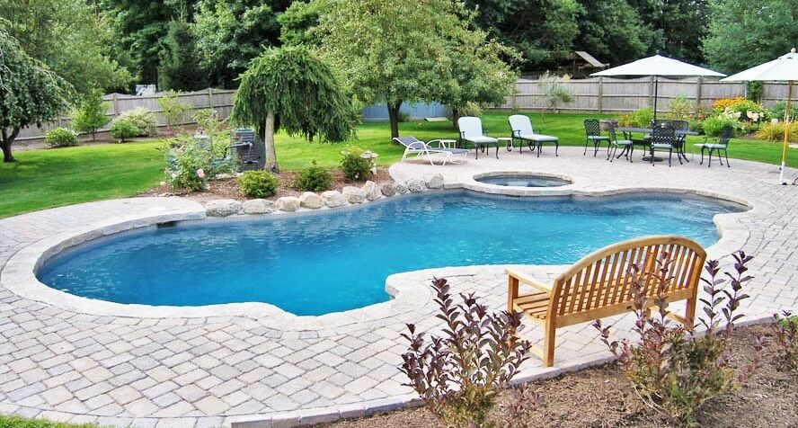 Aqua Pool & Patio gunite swimming pool construction in Connecticut showing swimming pool with attached spa and patio seating