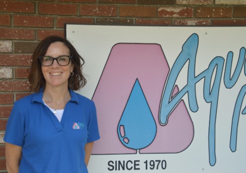 Kris Gorman in front of an Aqua Pool of CT sign